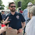 Rep. Mike Lawler campaigning in New York's 17th Congressional District during the 2026 election while highlighting campaign fundraising efforts.