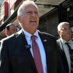 Bruce Blakeman speaks at a podium as New York Democrats seek an investigation into his campaign finance reports.